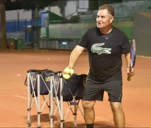 Marcel Petit coaching on a clay court at night